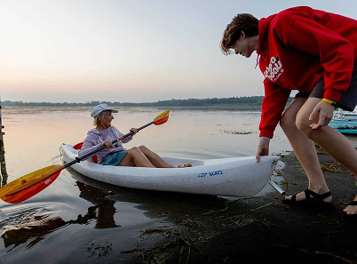 Worker helping kayaker